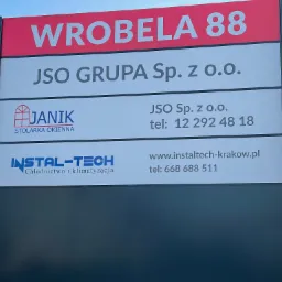 Tablica reklamowa z logotypami firm: Janik Stolarka Okienna, JSO Grupa, Instal-Tech Chłodnictwo i Klimatyzacja oraz adresem Wrobela 88.
