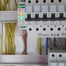 Panel elektryczny z widocznymi przewodami w kolorach żółto-zielonym, brązowym i niebieskim, zabezpieczeniami Legrand i Eaton, oraz modułem LK-713 z diodami sygnalizacyjnymi L1, L2, L3.