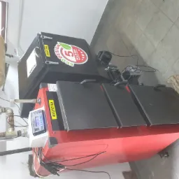 Nowoczesny piec na paliwo stałe z panelem sterowania, zbiornikiem na wodę i widocznymi elementami instalacji grzewczej w kotłowni.