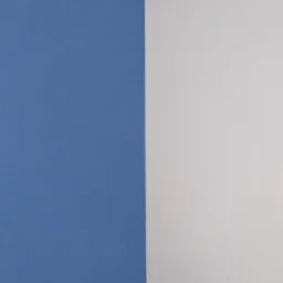 Pomarańczowa ściana z fragmentem białej ściany obok, widoczne delikatne nierówności powierzchni.