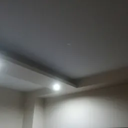 Wykończony sufit podwieszany z oświetleniem punktowym w mieszkaniu w Przemyślu, widok z dołu.