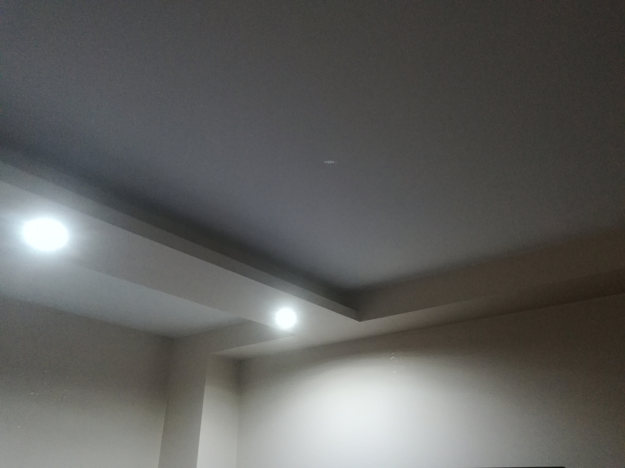 Wykończony sufit podwieszany z oświetleniem punktowym w mieszkaniu w Przemyślu, widok z dołu.