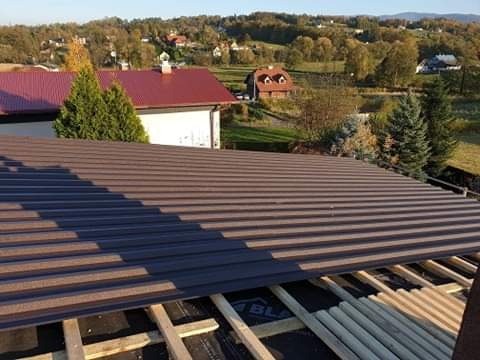 Prace przy wykonywaniu pokrycia dachowego blachą trapezową.