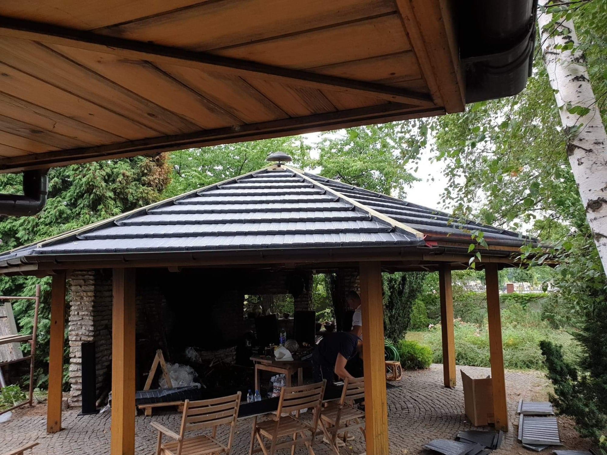 Prace przy wykonywaniu pokrycia dachowego altany gontem blaszanym