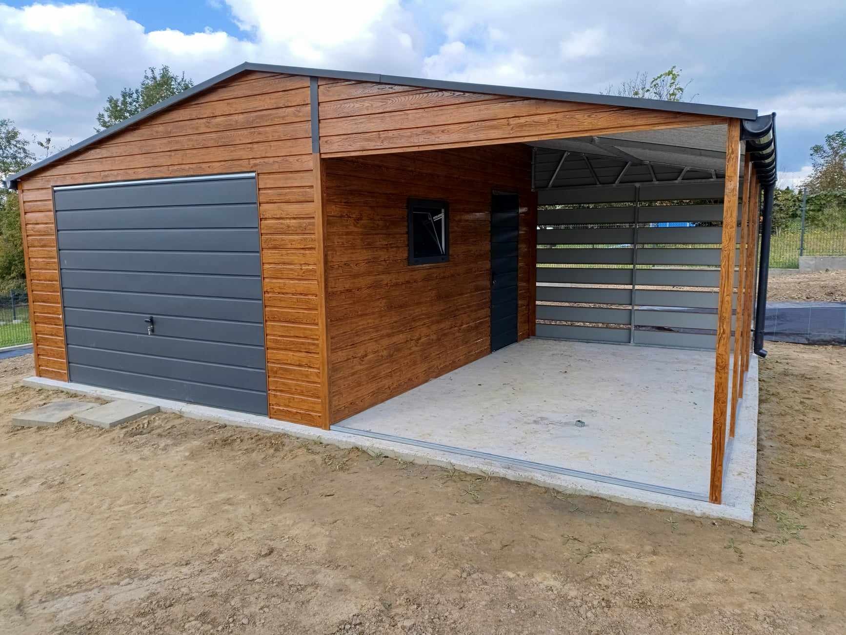 Nowo wybudowany garaż blaszany z bramą segmentową w kolorze antracytowym i drewnopodobną elewacją, z dodatkową wiatą z tyłu, widoczne elementy konstrukcyjne i orynnowanie.