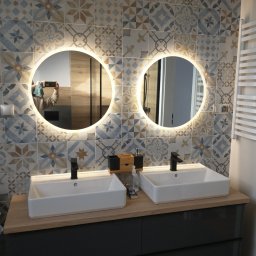 Stel-BUD - Nowoczesna łazienka z dwoma umywalkami nablatowymi, okrągłymi lustrami z podświetleniem LED i dekoracyjnymi płytkami ściennymi w stylu patchwork. Widoczny grzejnik drabinkowy i armatura w kolorze...