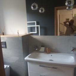 Stel-BUD - Nowoczesna łazienka z szarą glazurą, białą umywalką z szafką, chromowaną armaturą i kulistymi lampami wiszącymi, widoczne odbicie fotografa w lustrze.