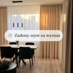 Jasne, długie zasłony z delikatnego materiału w przestronnym salonie z drewnianą podłogą i nowoczesnym oświetleniem.