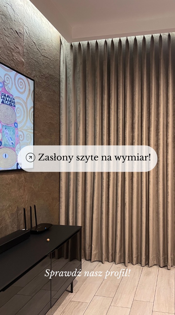 Beżowe, plisowane zasłony na wymiar, wiszące od sufitu do podłogi, obok ściany z kamienia dekoracyjnego i czarnej szafki RTV.