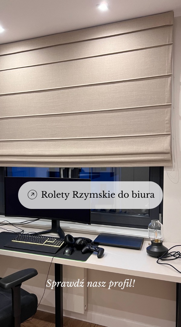 Beżowe rolety rzymskie zamontowane w oknie nad biurkiem z komputerem i akcesoriami gamingowymi w nowoczesnym pokoju.