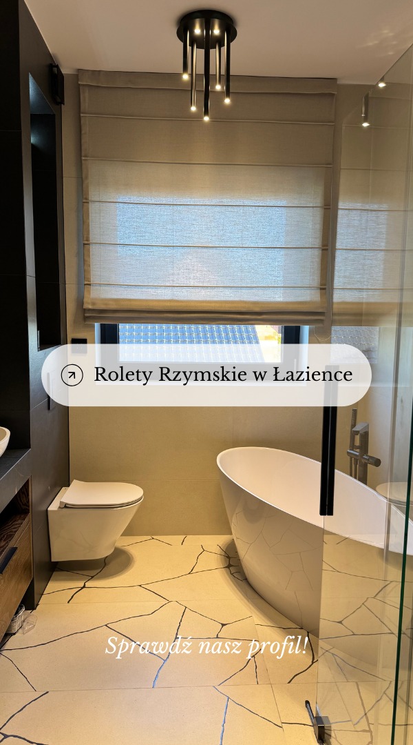 Beżowa roleta rzymska zamontowana w oknie łazienki nad wolnostojącą wanną na tle płytek podłogowych z motywem pęknięć.