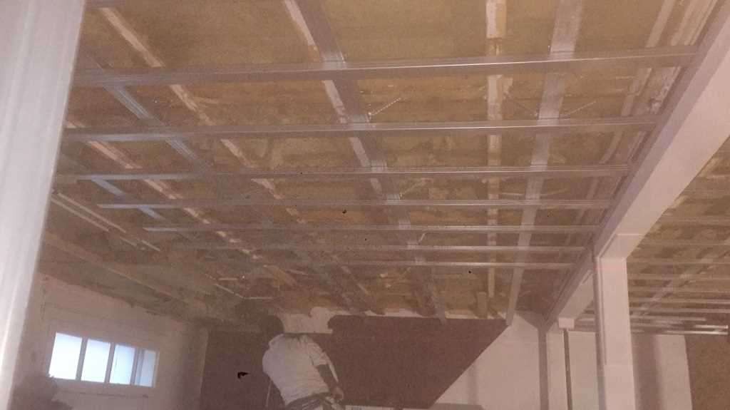 Montaż stelaża sufitu podwieszanego z płyty karton gips, widoczna izolacja i fragment okna.