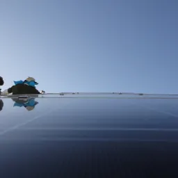 Montaż paneli słonecznych na dachu w słoneczny dzień, dwóch monterów w kapeluszach pracuje na wysokości, widoczne metalowe elementy mocujące.