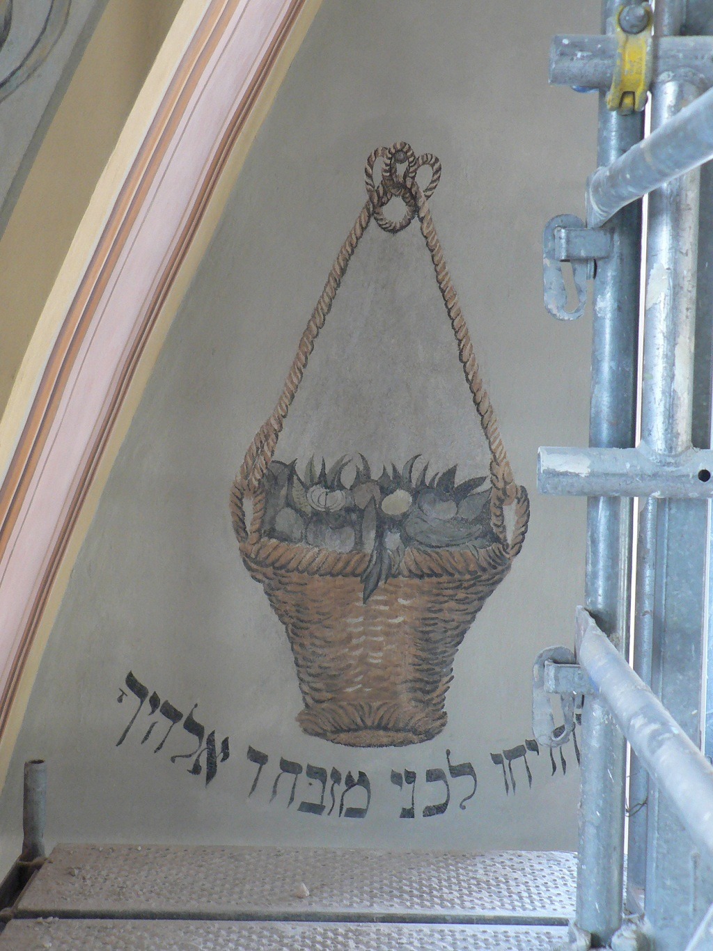 Fragment polichromii synagogi w Dąbrowie Tarnowskiej przedstawiający kosz z owocami, widoczne rusztowanie.