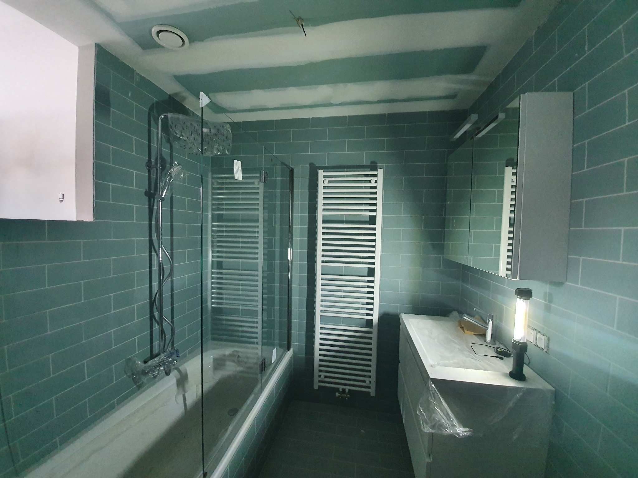 Montaż wanny, parawan szklany, umywalka z szafką wiszącą, szafka wisząca z lustrem.