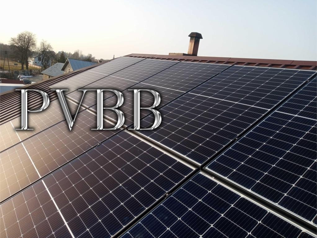 Panel fotowoltaiczny zamontowany na dachu domu jednorodzinnego z kominem, widok z góry pod lekkim kątem.