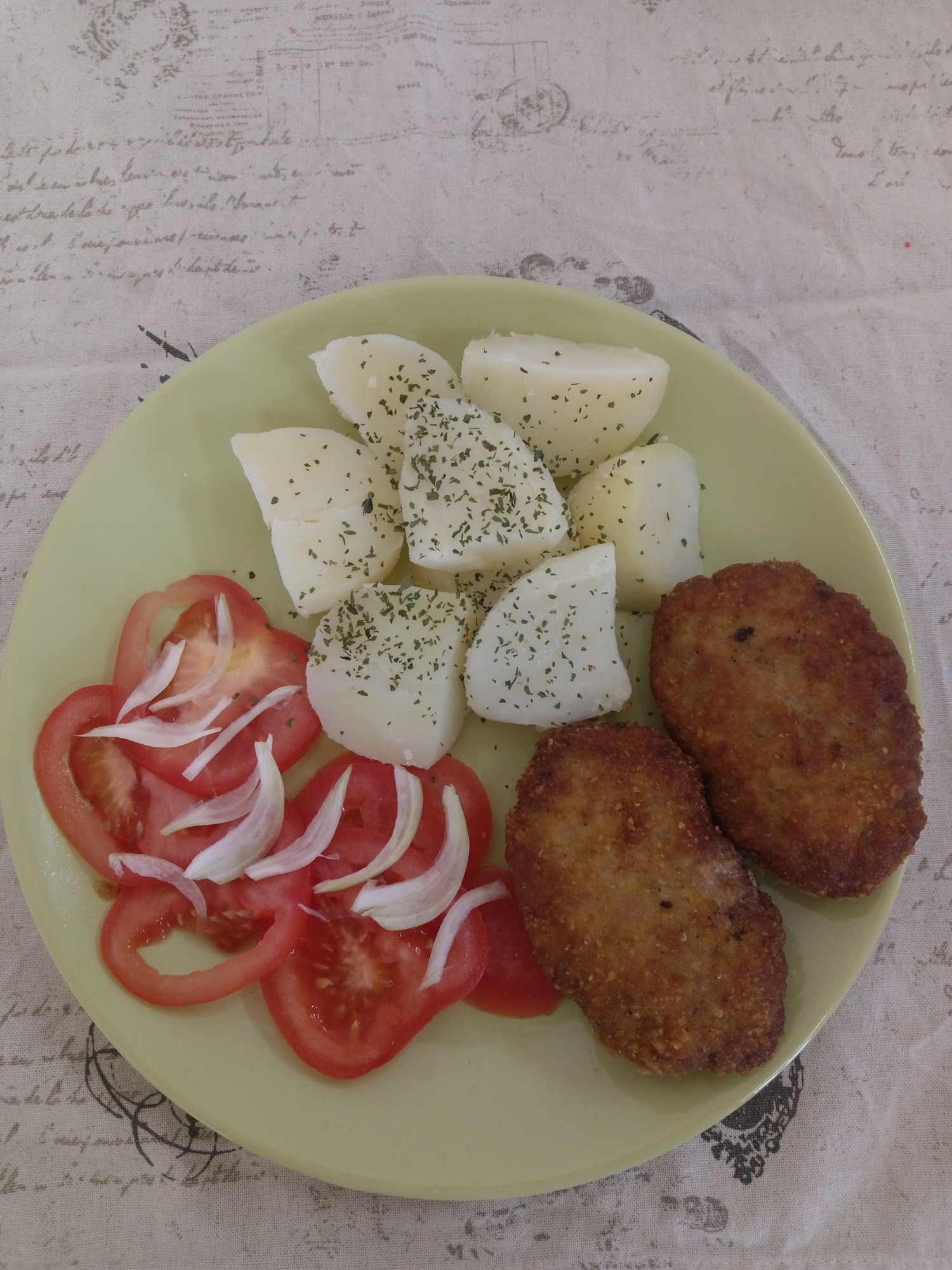 kotlet mielony z ziemniakami i pomidor z cebulką.