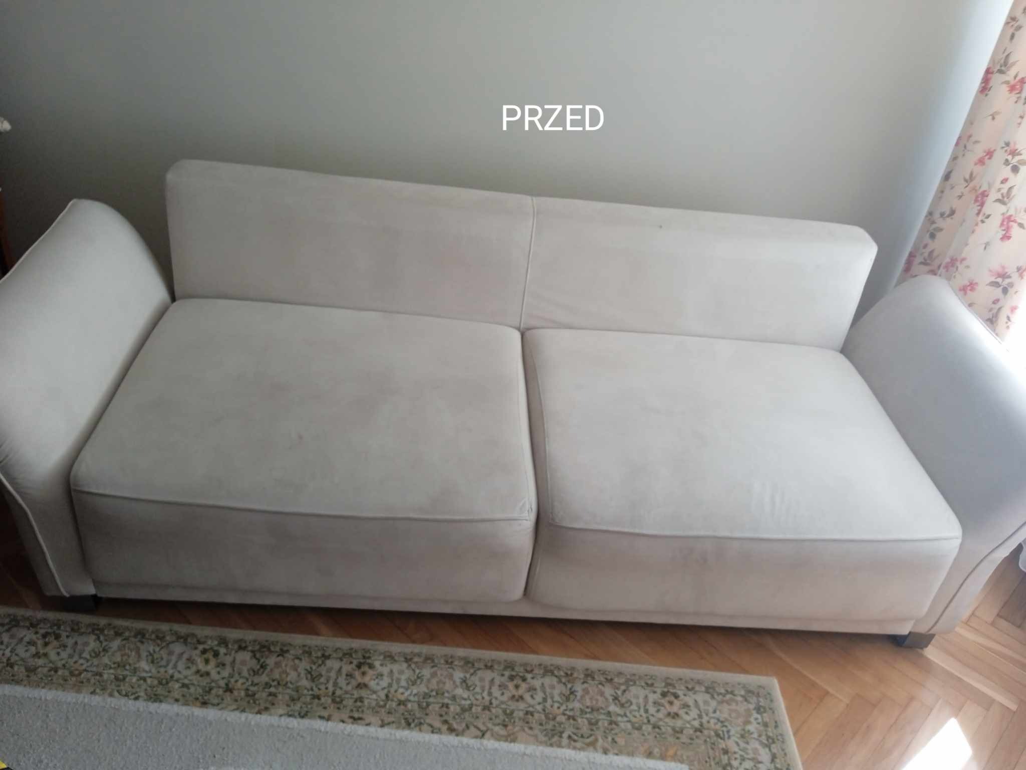 Jasna, dwuosobowa kanapa z widocznym zabrudzeniem na siedzisku, sfotografowana z perspektywy podłogi, z napisem 'PRZED' w górnej części zdjęcia.