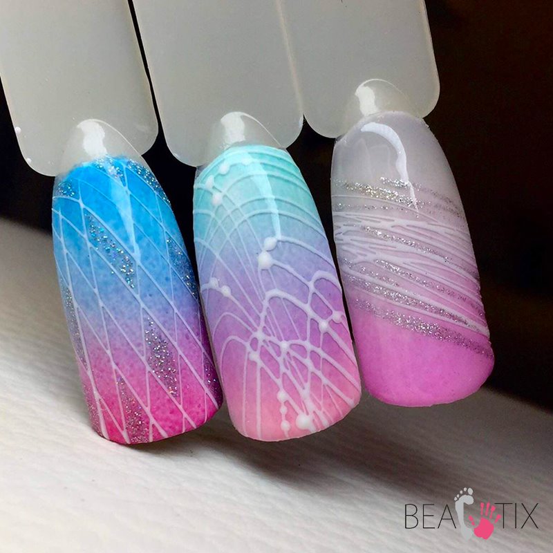 Trzy wzorniki paznokci z gradientem kolorów i geometrycznymi zdobieniami: niebiesko-różowy z siatką i brokatem, turkusowo-różowy z pajęczyną z kropek oraz różowo-biały z nieregularnymi liniami...