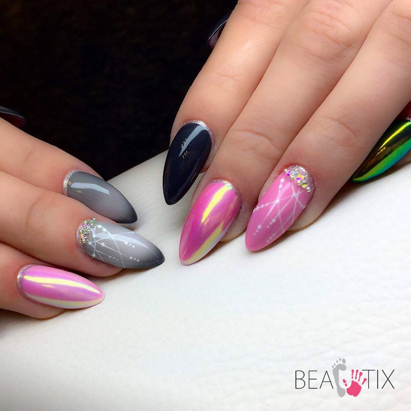 Dłonie z pomalowanymi paznokciami w różnych stylach: ombre szarości, holograficzny róż, granat z srebrnym paskiem przy skórkach, różowy z białym wzorem i cyrkoniami, ułożone na białym tle.