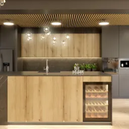 Nowoczesna kuchnia z drewnianymi frontami szafek, wyspą z marmurowym blatem, oświetleniem LED i przeszkloną witryną na wino, uzupełniona o dekoracyjny żyrandol.