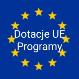 Flaga Unii Europejskiej z napisem 'Dotacje UE Programy' w centrum, otoczona dwunastoma żółtymi gwiazdami.