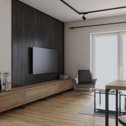 Katarzyna Krejczy-Myślicka- ARCHITEKTURA I WNĘTRZA - Nowoczesny salon z drewnianą podłogą, ścianą akcentującą z ciemnego drewna, telewizorem, niską komodą z figurkami KAWS, szarym fotelem i stołem z przezroczystymi szklankami.