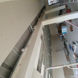 Zaklad-elektrobudowlany - Wnętrze w trakcie prac wykończeniowych: widoczna konstrukcja metalowa pod zabudowę ścian gipsowo-kartonowych, instalacje elektryczne w korytach, surowa ściana z widocznymi punktami mocowania,...