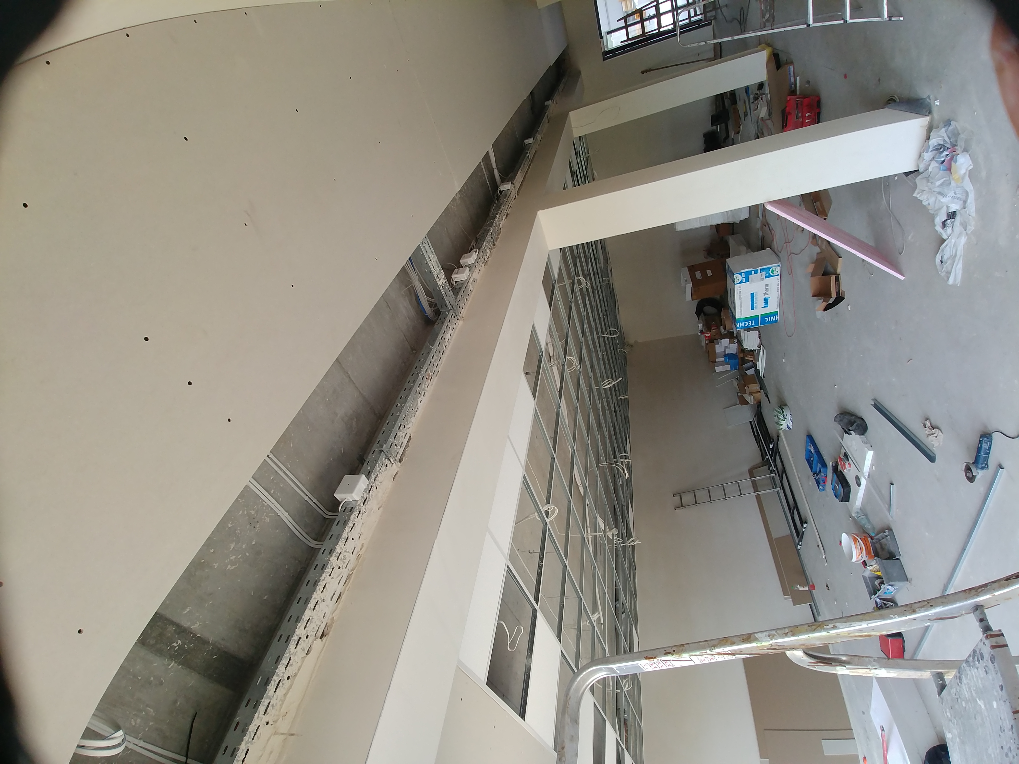 Wnętrze w trakcie prac wykończeniowych: widoczna konstrukcja metalowa pod zabudowę ścian gipsowo-kartonowych, instalacje elektryczne w korytach, surowa ściana z widocznymi punktami mocowania,...