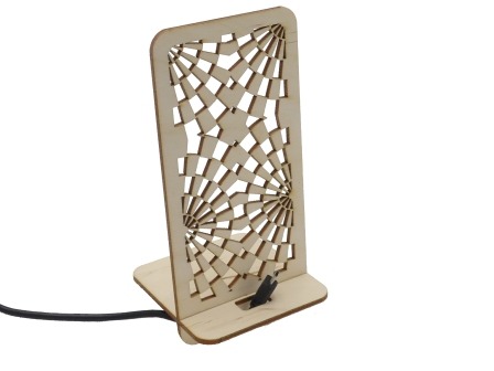 Drewniany stojak na telefon z wycinanym laserowo ażurowym wzorem przypominającym pajęczynę, podłączony kablem.