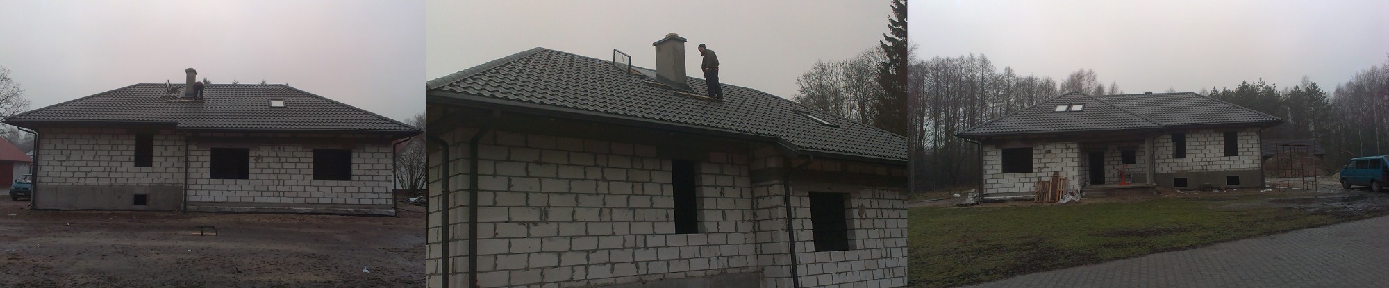 Dom jednorodzinny w trakcie krycia dachu z ciemnej dachówki, dekarz na dachu przy kominie, surowy stan elewacji z betonu komórkowego, pochmurna pogoda.