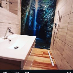 RemontujemY - Nowoczesna łazienka z umywalką nablatową, kabiną prysznicową bez brodzika i fototapetą z motywem wodospadu na ścianie.