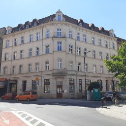 Gabinety Psychoterapii ARIADNA Katowice Opolska - Kamienica narożna z balkonem, jasna elewacja, widok z poziomu ulicy, zaparkowane samochody i zieleń miejska.