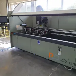 Frezarka CNC do obróbki profili aluminiowych, z widocznym panelem sterowania i logiem Emmegi.