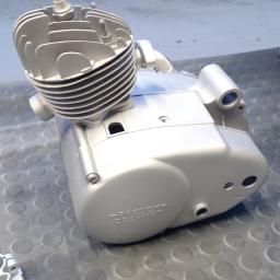 Sandblast - Elementy silnika motocyklowego po renowacji, pokryte srebrną farbą, widoczne napisy 'Predom-Dezamet'.