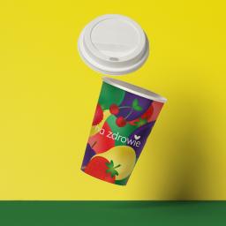 Unicorn design - Papierowy kubek z nadrukiem owoców i napisem 'na zdrowie' unosi się w powietrzu obok białej pokrywki na żółto-zielonym tle.