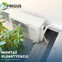 Frigus Instalacje - Zewnętrzna jednostka klimatyzacji Fuji Electric DC Inverter R32 zamontowana przy ścianie budynku, widoczna instalacja odprowadzająca skropliny, obok roślina ozdobna.