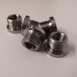 M-TECH Sp. Z o.o. - Srebrne, metalowe tuleje z gwintem wewnętrznym i zewnętrznym, ułożone na białym tle, widoczne ślady obróbki.