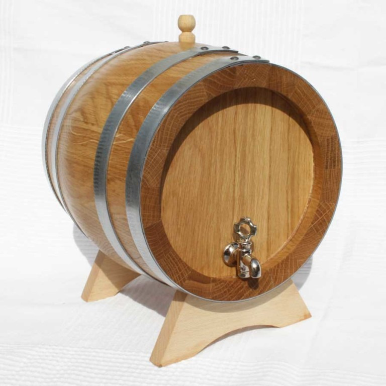 Mała, dębowa beczka na drewnianym stojaku z metalowym kranikiem, otoczona srebrnymi obręczami.