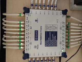 Rozdzielacz multiswitch TT-9/16 z podłączonymi kablami koncentrycznymi, zainstalowany w Limanowej. Widoczny detal złączek i oznaczeń na urządzeniu.