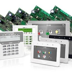 Inti Sp. z o.o. - Zestaw urządzeń alarmowych marki Satel: centrale alarmowe z klawiaturami, panele dotykowe i płytki drukowane w tle.