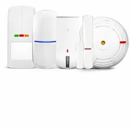 Zestaw białych czujników alarmowych różnego typu, w tym ruchu, otwarcia okien i dymu, na białym tle. Widoczne diody sygnalizacyjne na niektórych urządzeniach.