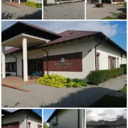 Elewacja budynku z beżową fasadą, brązowymi ramami okiennymi i ceglanym detalem z nazwą 'Niezapominajka Gościniec'. Uwagę zwracają starannie przycięte krzewy i kostka brukowa.