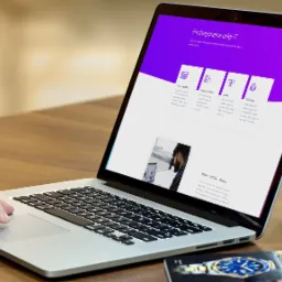 Mężczyzna korzysta z laptopa prezentującego ofertę agencji IT z zakresu stron WWW, aplikacji mobilnych, grafiki i marketingu, widoczny zegarek na stole.