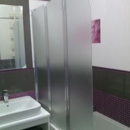 TOP-Dom - Nowoczesna łazienka z umywalką nablatową, baterią i szklanym parawanem nawannowym z trzema segmentami, wykończona płytkami w odcieniach szarości i fioletu.