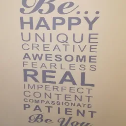 Napis na ścianie w kolorze szarym: Be Happy, Unique, Creative, Awesome, Fearless, Real, Imperfect, Content, Compassionate, Patient, Be You