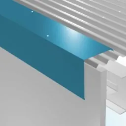 Narożnik budynku w Warszawie z niebieską obróbką blacharską, widoczna blacha trapezowa na dachu i konstrukcja nośna.