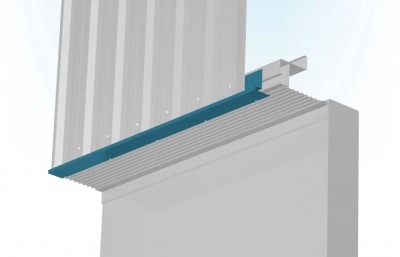 Szary budynek z zamontowaną, niebieską listwą okapową i blachą trapezową przymocowaną do ściany za pomocą nitów.