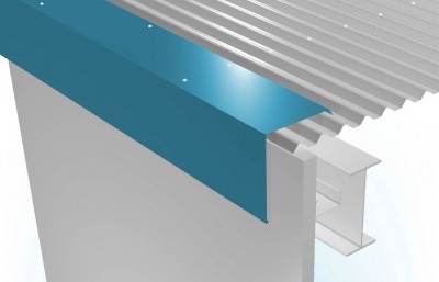 Narożnik budynku w Warszawie z niebieską obróbką blacharską, widoczna blacha trapezowa na dachu i konstrukcja nośna.