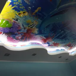 Podwieszany sufit z motywem podwodnego świata: delfiny, ryby, koralowce, oświetlenie LED wzdłuż krawędzi, widok z dołu.